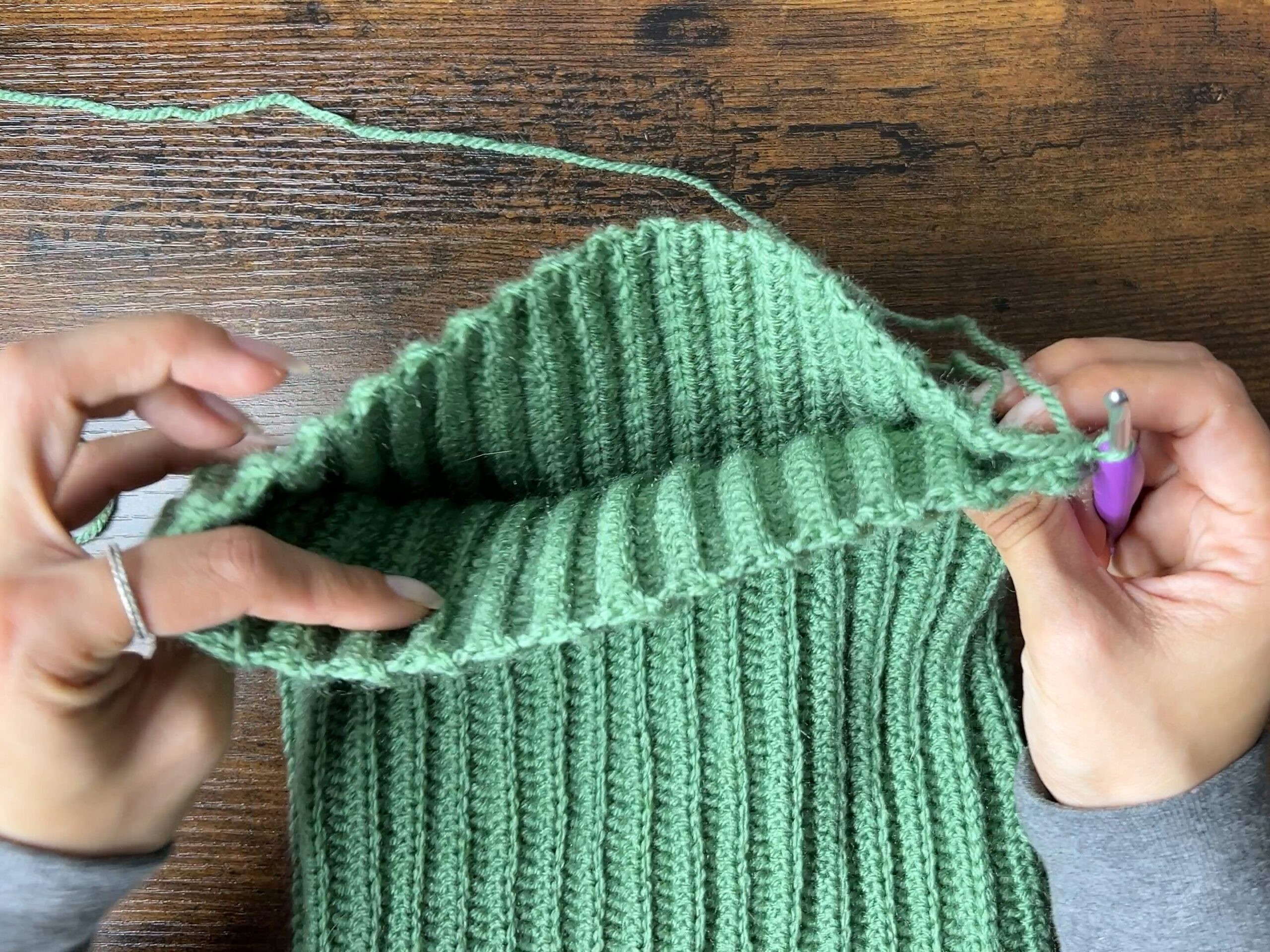 Image showing how to sew the top of the crochet cat ear beanie closed using a yarn needle