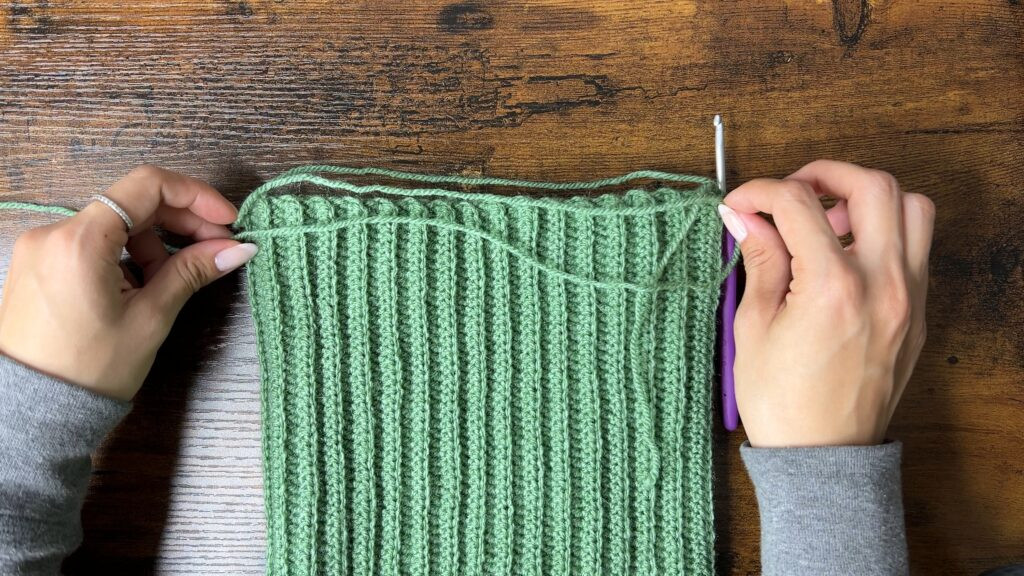 Image showing a close up of whip stitching the top of the crochet cat ear beanie closed