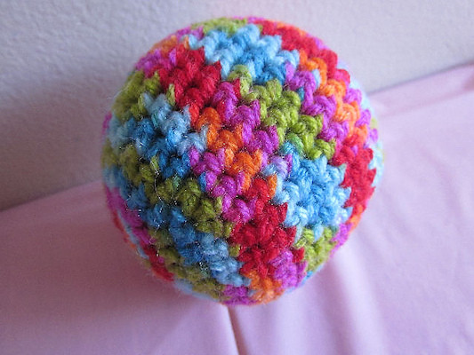 Two images of a simple round crochet ball cat toy in different yarn colors, ideal for chasing