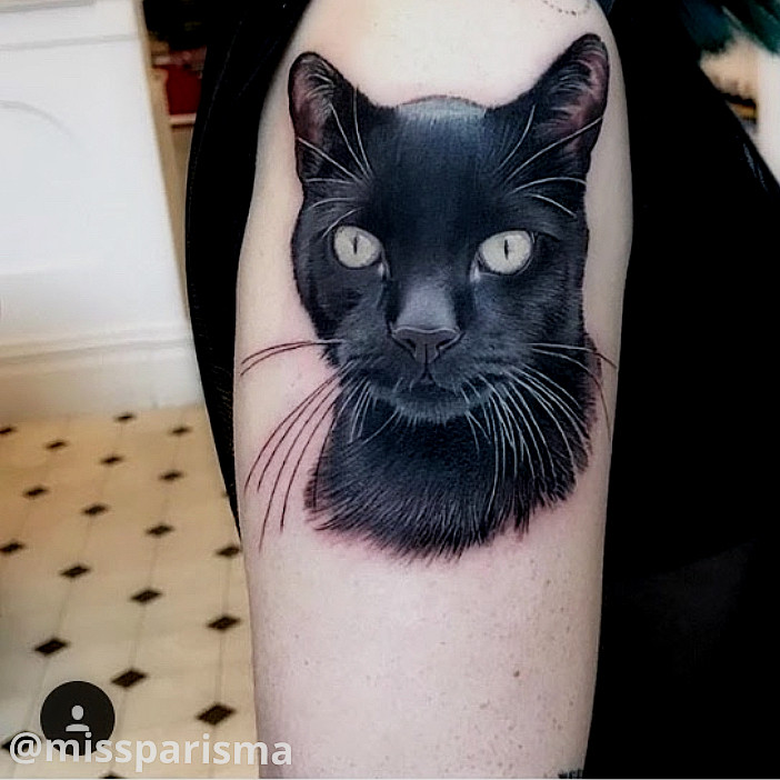 Detailed black cat portrait tattoo
