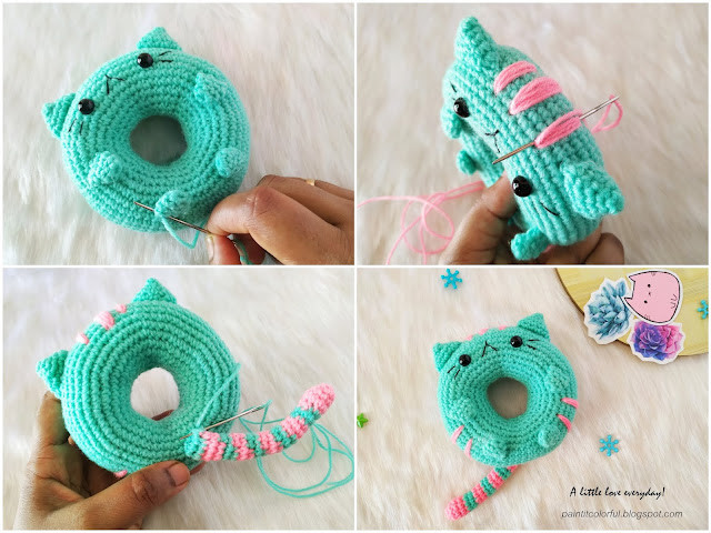 Two finished donut cat amigurumi, one pink and one purple, laying on a wooden surface
