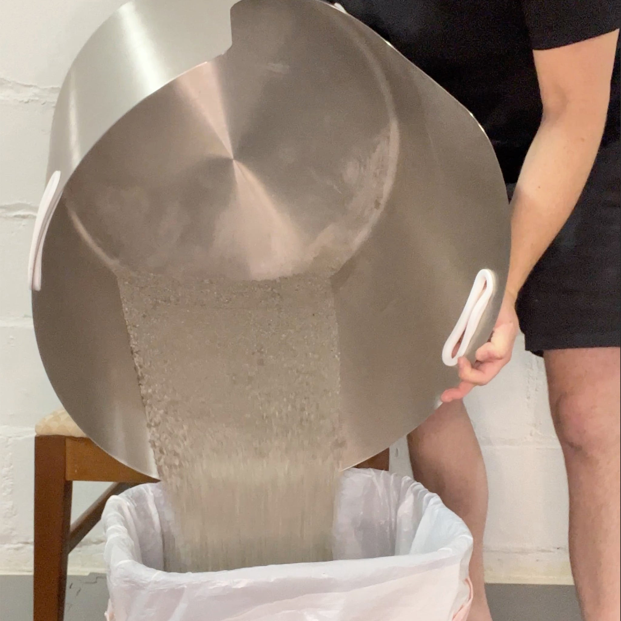 Demonstrating the heavy weight of the Less Litter L-5 stainless steel cat litter pan during cleaning.