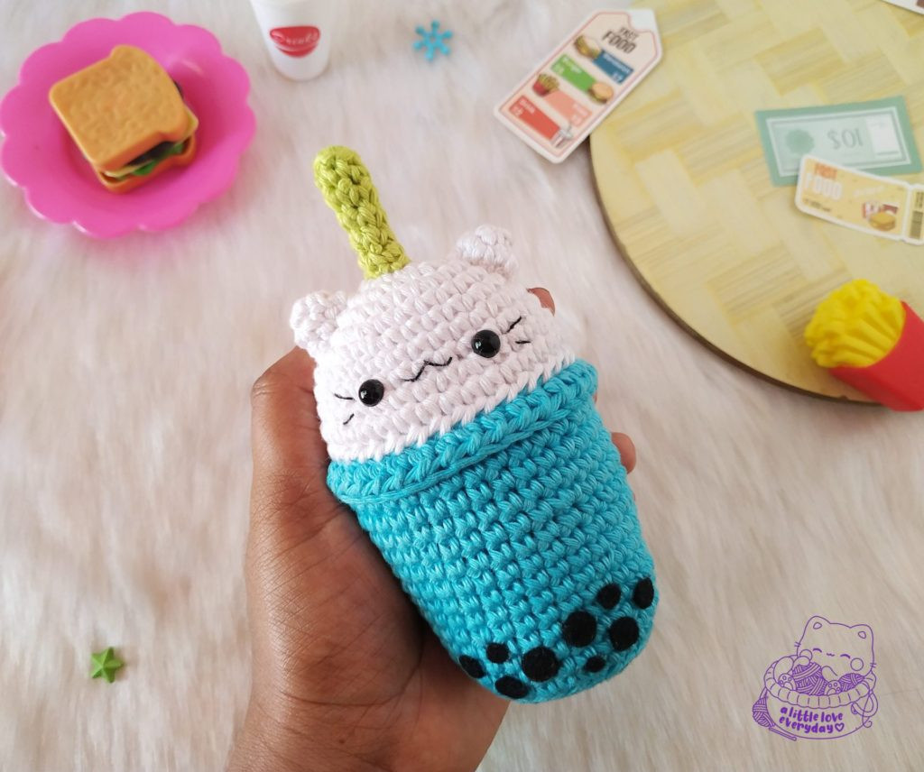 Close-up of a boba cat amigurumi cup being crocheted in pink yarn.