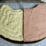 Piping bag filled with vibrant pink strawberry mousse for Cookie Cat cake layers