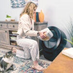 woman adding premium clumping litter, the best cat litter for Litter-Robot 4