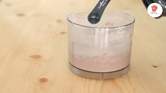 Combining flour, icing sugar, and cocoa powder in a mini chopper for chocolate cookie dough.