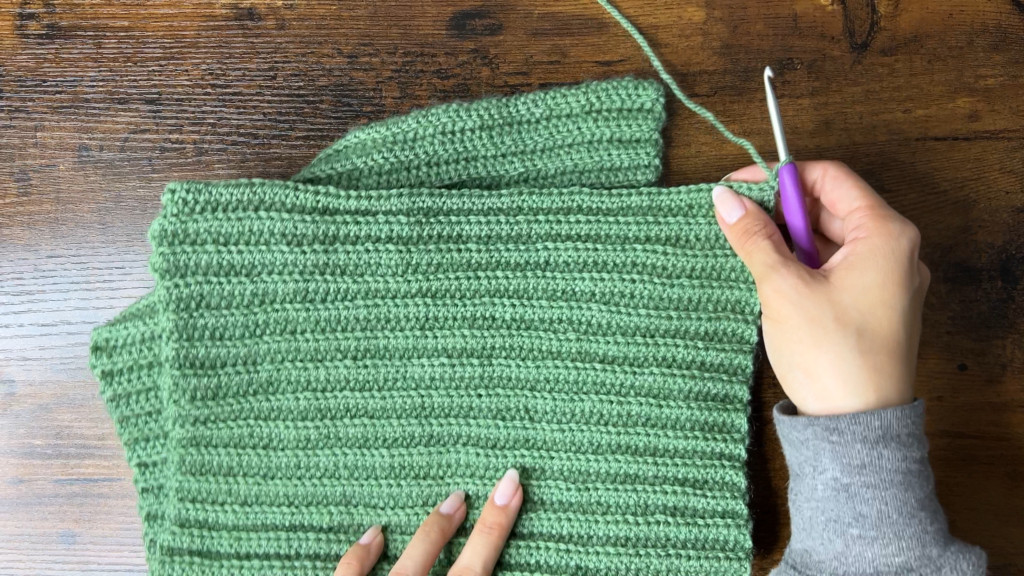 Still image from the video demonstrating the slip stitch seam to join the sides of the crochet cat ear beanie