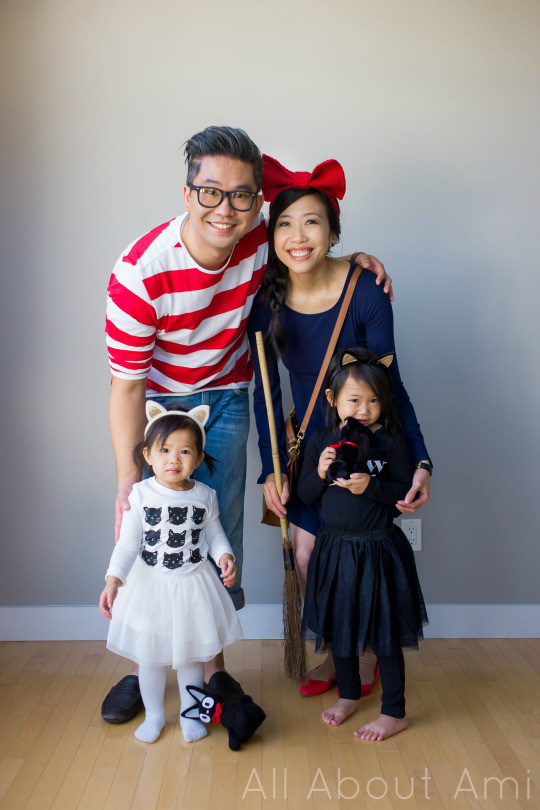 Family dressed in Kiki's Delivery Service costumes with crocheted Jiji cat