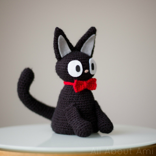 Jiji amigurumi wearing the red bow collar, a cute accessory for the crocheted cat