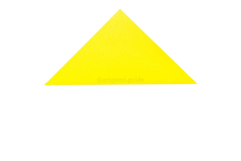 Folding the bottom corner to the top corner to form a triangle for the origami cat face