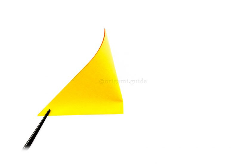 Marking the middle point of the bottom edge of the triangle by folding the right corner to the left corner