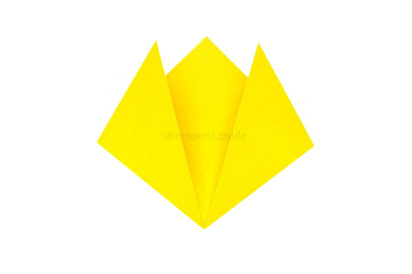 Folding the left corner upwards and to the left to create the second cat ear, matching the first